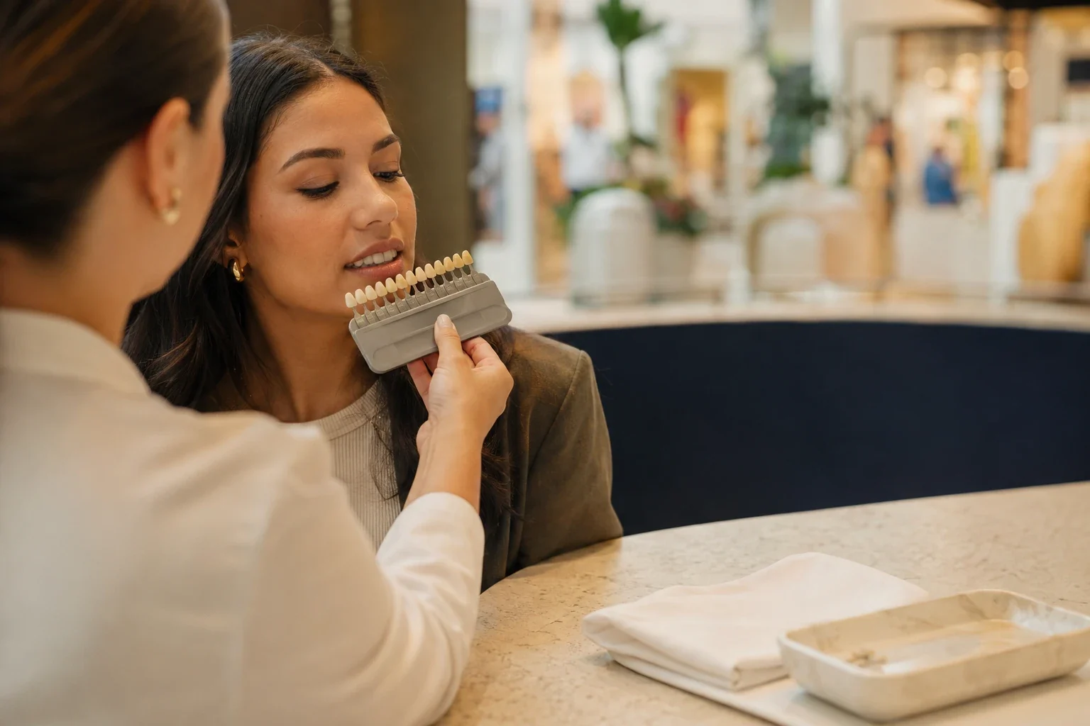 Guía de tono dental sostenida junto a una sonrisa durante la medición